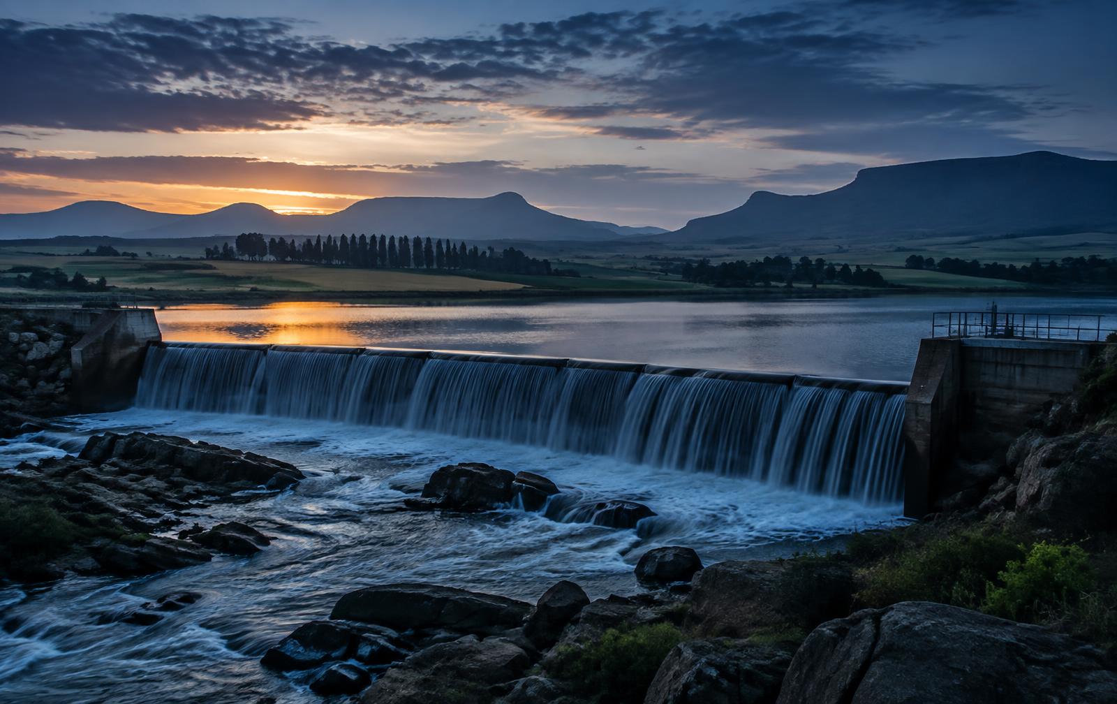 Water flowing over a weir on a South African irrigation dam at dawn